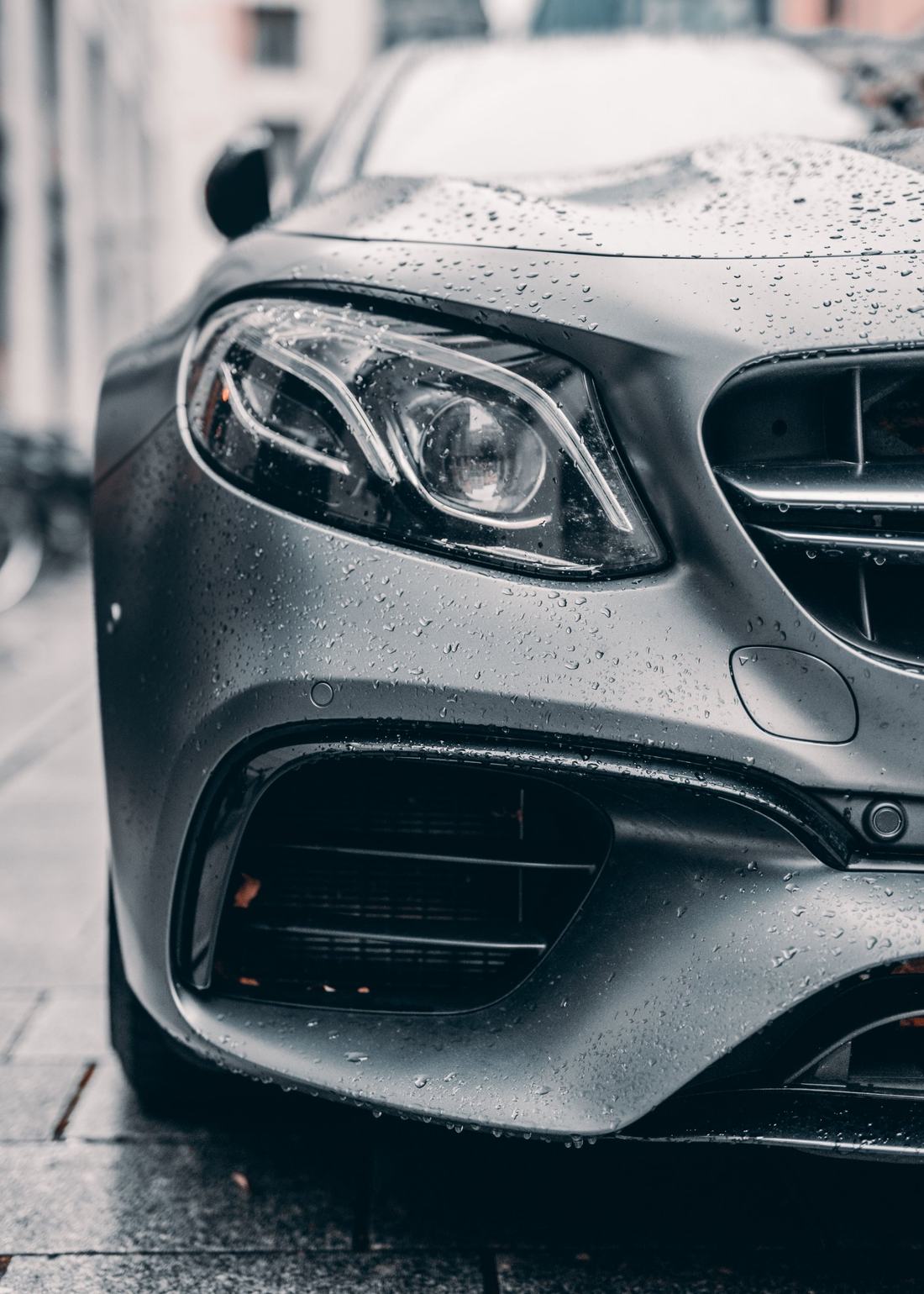 Rain beading on the front end of a satin gray sedan after a coating