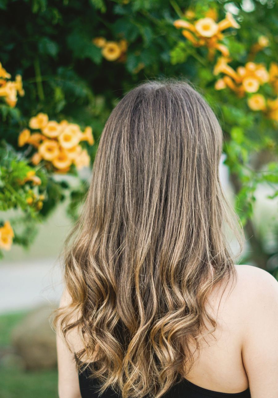 Long honey balayage in soft waves, seen from behind