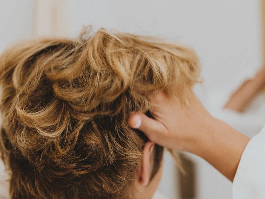 Short, textured golden crop being styled by hand