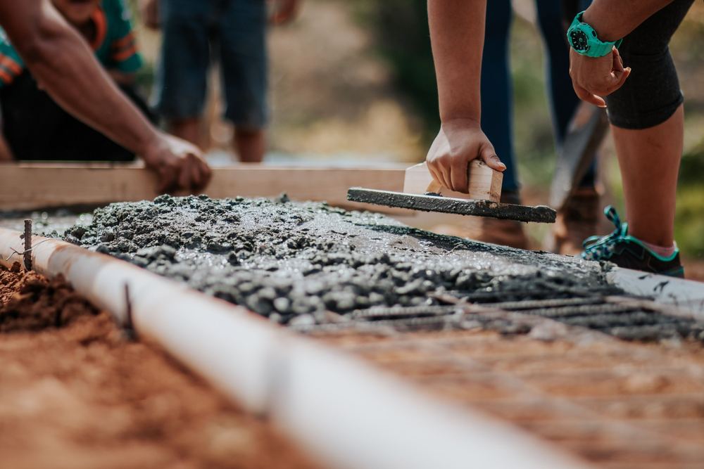 Hand float smoothing wet concrete inside wood forms