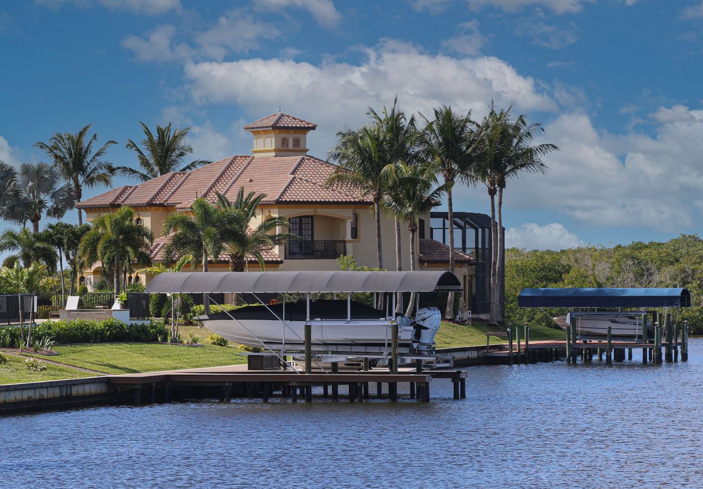 Tile-roof home on a canal with a covered boat lift