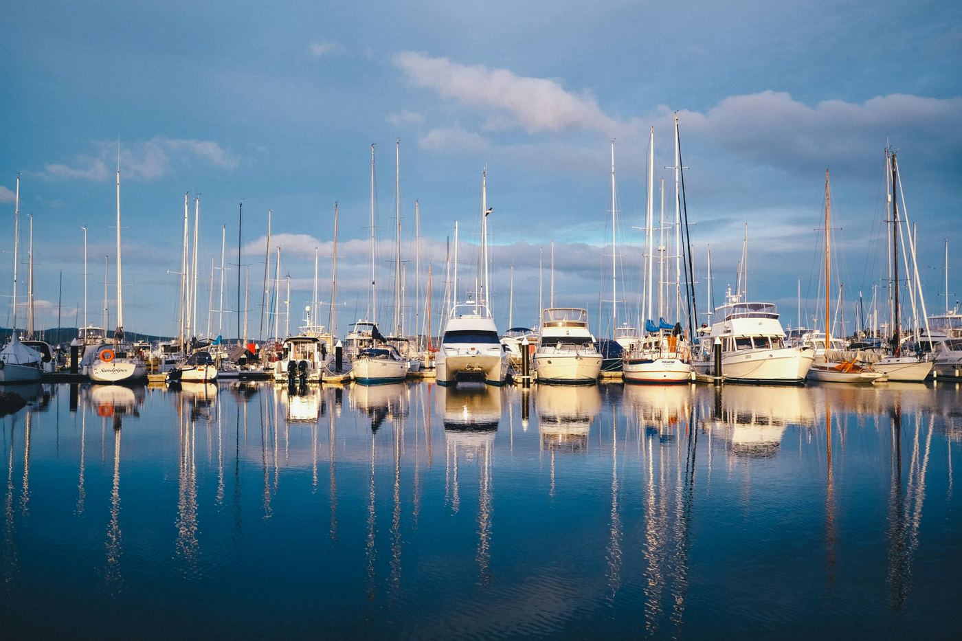Sailboats and yachts reflected in a calm marina