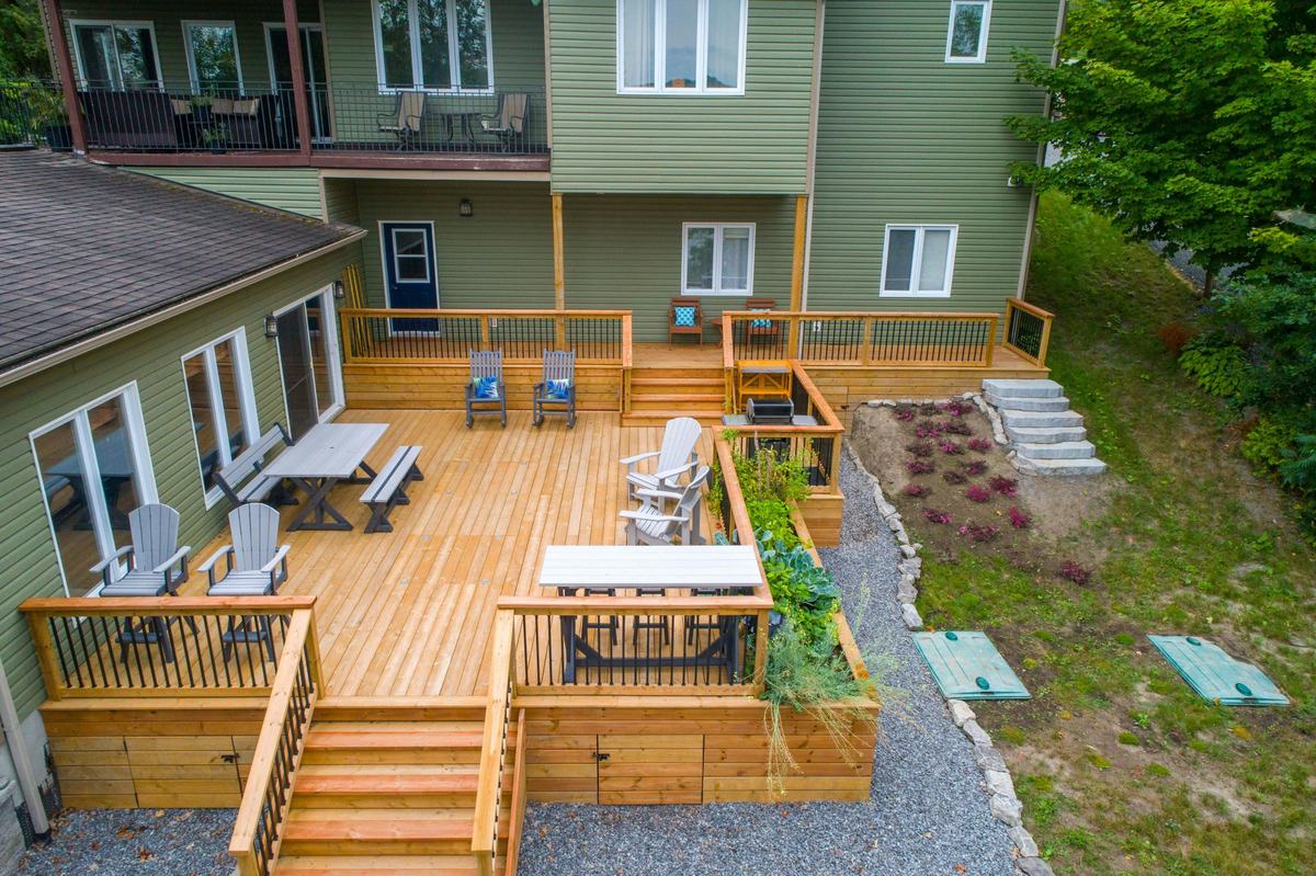 Two-level cedar deck with black metal balusters, wide steps and built-in planters