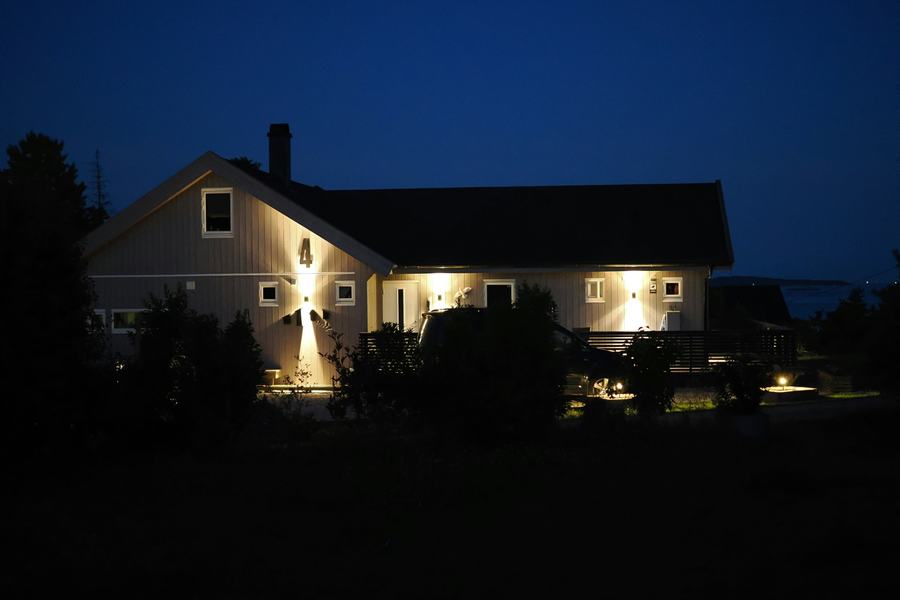 House at night with wall lights and path lights glowing