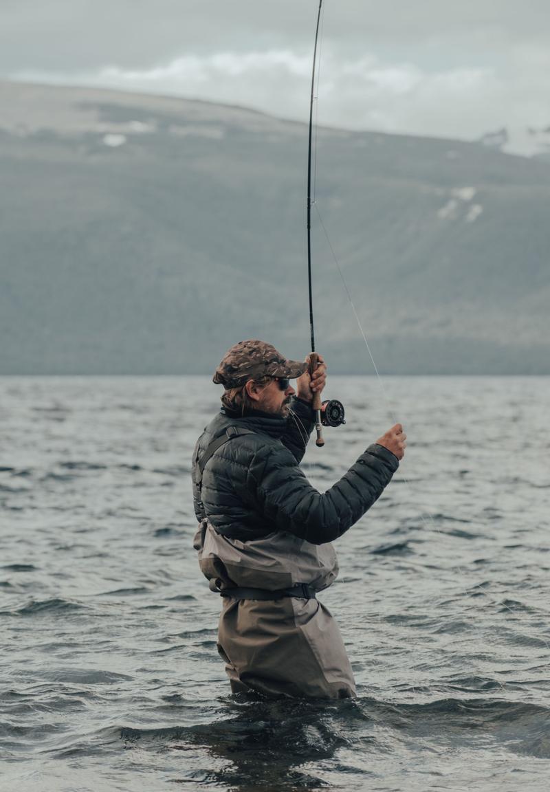 Angler wading waist-deep and stripping in line
